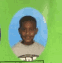 a young boy is smiling for the camera in a picture frame on a green background .