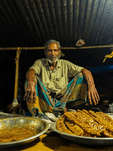 a man sits under a roof next to a plate of food