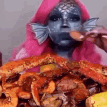 a woman in a fish costume is eating crabs and shrimp .