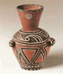 a clay vase with a black and white design on it is sitting on a table .