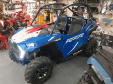 a blue and white atv with the word polaris on the side