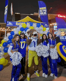 a group of cheerleaders and a mascot are posing for a photo