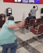 a man in a blue shirt is standing in front of a vending machine that says ' coca cola ' on it