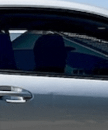 a close up of a car door with a reflection of a person in it .