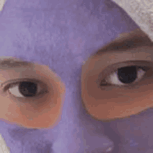 a close up of a person 's face with a purple mask on .