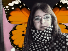 a woman wearing glasses and a polka dot scarf has butterfly wings on her back