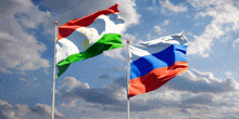 two flags are waving in the wind against a cloudy blue sky