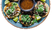 a blue plate topped with tacos and a bowl of salsa