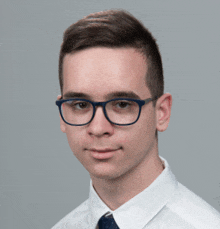 a young man wearing blue glasses and a white shirt