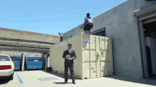 a man in a suit stands in front of a large shipping container that says ' container services ' on it