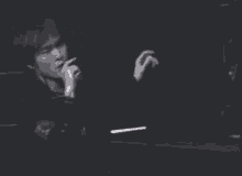 a man in a black jacket is singing into a microphone .