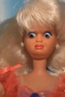 a barbie doll is wearing a red dress and making a funny face