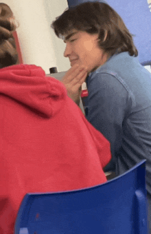 a man in a blue shirt is touching a woman 's face