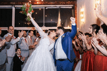 a bride and groom are kissing in front of their wedding guests