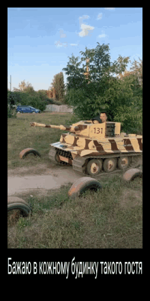 a man is driving a toy tank with the number 131 on it