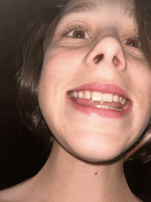 a close up of a person 's face with their mouth open and their teeth showing