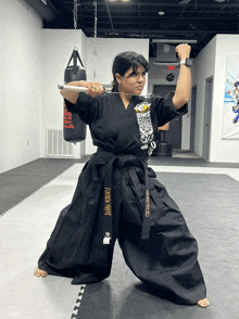 a woman in a black karate uniform with a black belt that says dawn norton