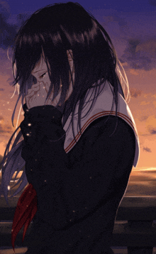 a girl in a school uniform is crying and covering her face with her hands