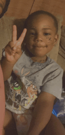 a young boy with a peace sign on his face