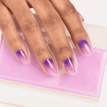 a close up of a woman 's nails with a purple and pink gradient