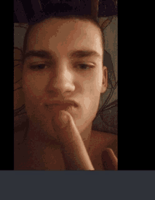 a young man is making a funny face with his finger in his mouth