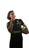 a man holding a rugby ball wearing a shirt that says suez