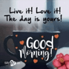 a cup of coffee with hearts on it and the words `` live it ! love it ! the day is yours ! ``