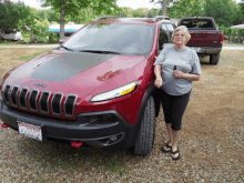 a woman stands in front of a red jeep with a license plate that says ' jacksonville ' on it