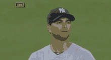 a man wearing a new york yankees hat looks at the camera