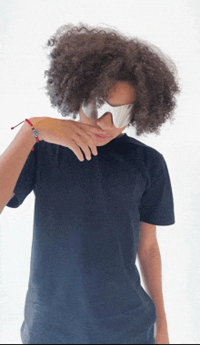 a person with curly hair wearing sunglasses and a bracelet