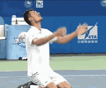 a man in a white shirt is kneeling on a tennis court in front of a sign that says cta