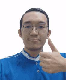 a man wearing glasses and a blue shirt gives a thumbs up sign