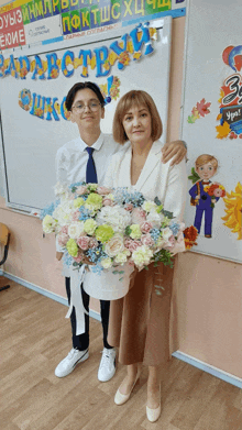 a woman holding a bouquet of flowers stands next to a young boy