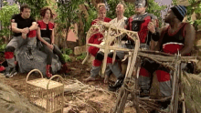 a group of people are sitting around a wooden structure and one of them is wearing a black and white striped hat