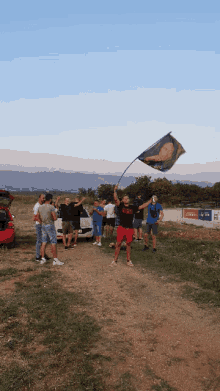 a group of people standing in a field with one man wearing a shirt that says ' a ' on it