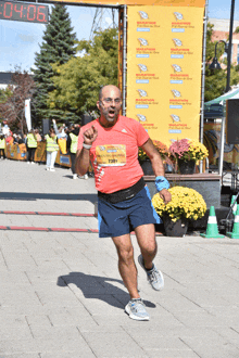 a man is running in front of a marathon sign