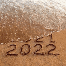 the word 2022 is written in the sand on the beach .