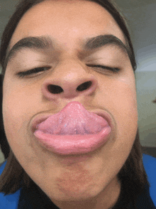 a close up of a person making a funny face with their tongue sticking out