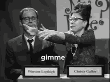 a black and white photo of a woman pointing at a man with the word gimme on the bottom right