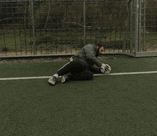 a man is kneeling on a soccer field holding a ball