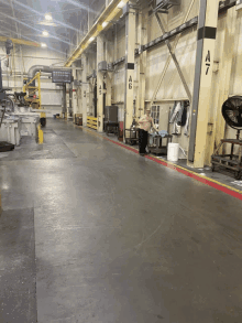 a man is standing in a warehouse with a 7 on the wall