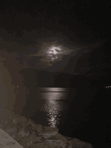 a full moon over a body of water