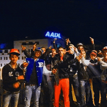 a group of young men are posing for a picture in front of a building that says aadl