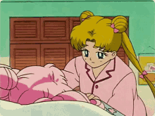 a girl in a pink pajamas is standing next to a bed