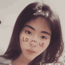 a young woman has the word love painted on her face