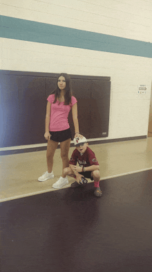 a girl in a pink shirt stands next to a boy wearing a maroon jersey with the word texas on it