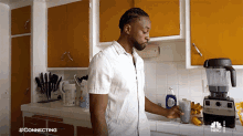 a man in a white shirt is standing in a kitchen with nbc written on the bottom of his shirt