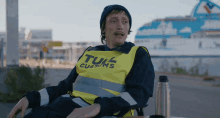 a man wearing a yellow vest that says tul customs on it