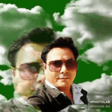 a man wearing sunglasses stands in front of a green background with clouds .