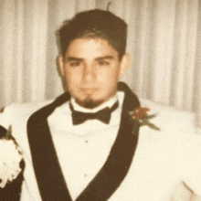 a man in a tuxedo with a flower on his lapel